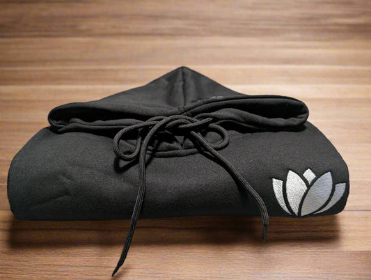 Black hoodie with a logo on a table in a casual setting