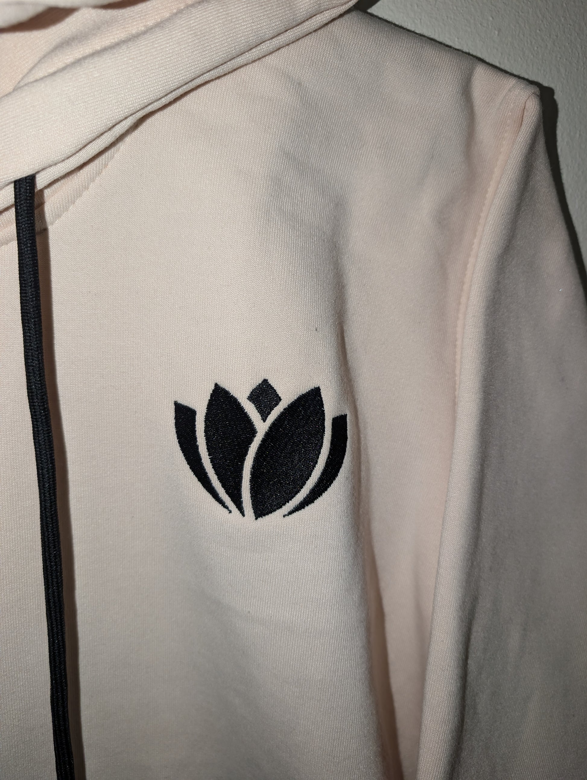 White jacket with a black lotus flower emblem on the back